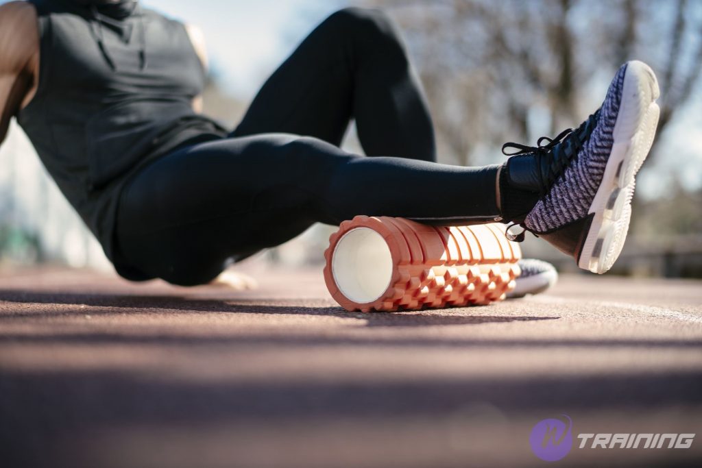 a man exercises with foam roller outside