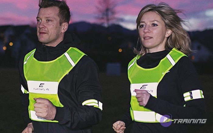 a couple is running with reflective vests