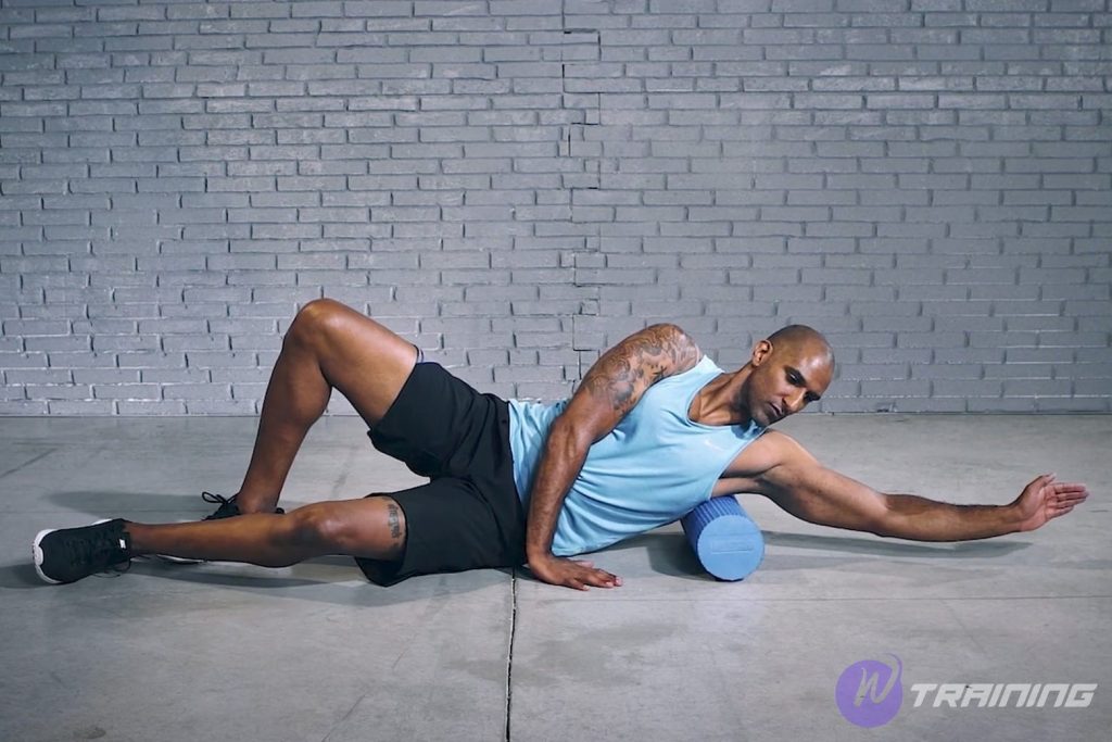 a man exercises with blue foam roller