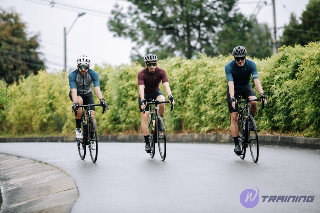 three men are cycling together