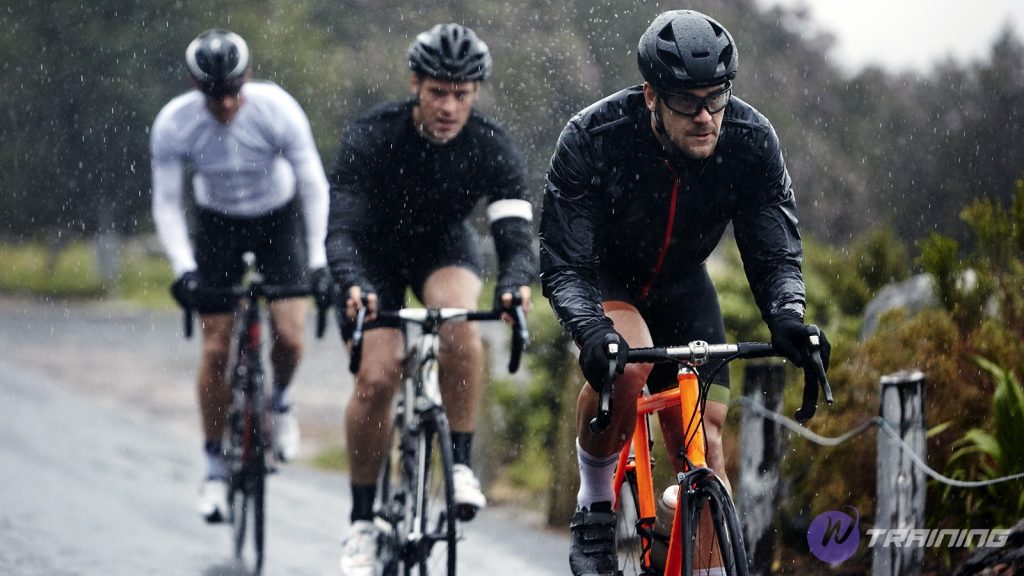 a group of cyclists are cycling in the rain