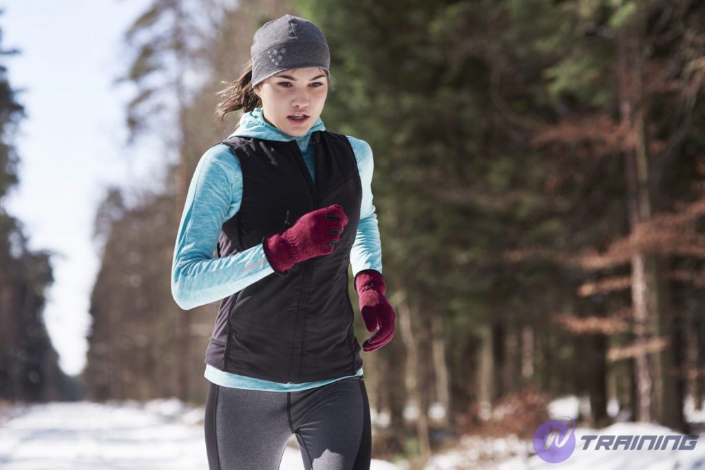 a girl is running in cold weather with fully gear